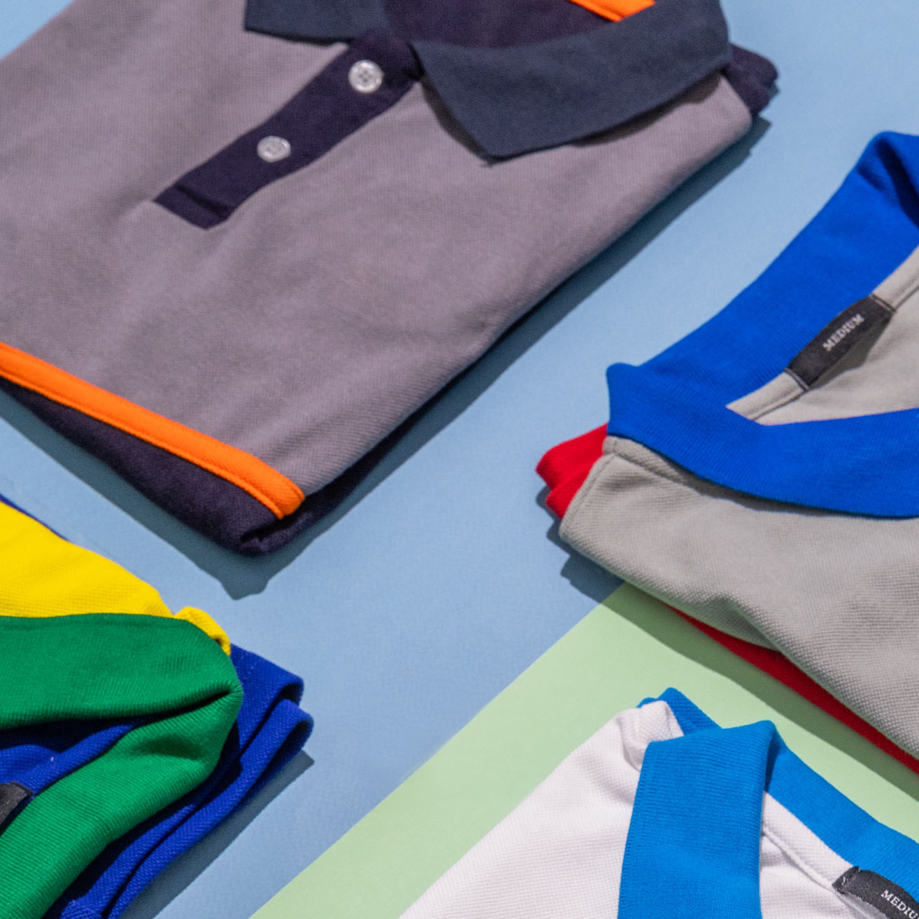 Folded shirts with colorful collars on a multicolored background