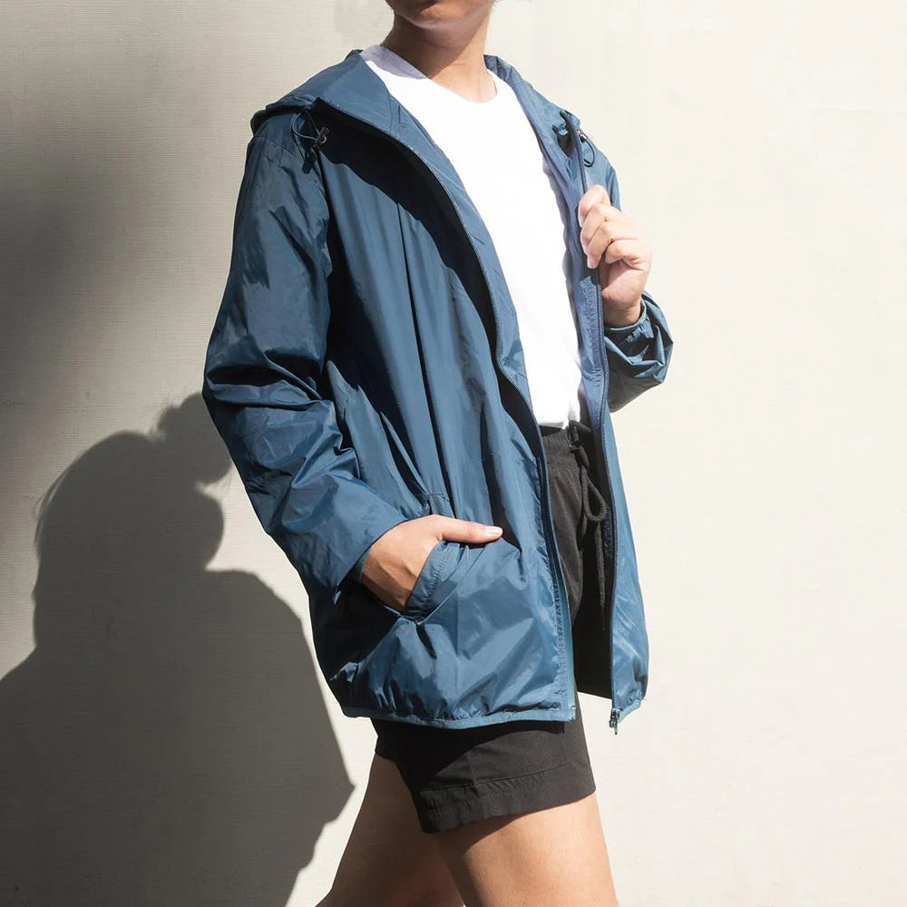 Person wearing a blue jacket against a neutral background